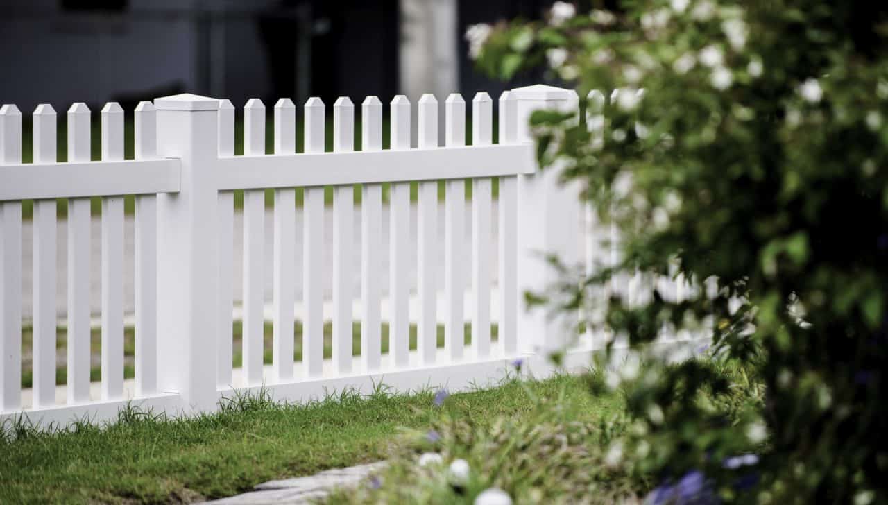 White Vinyl Fence In A Yard With Trees